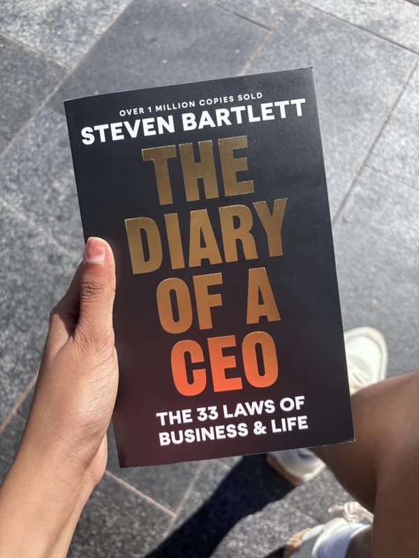 Holding a copy of The Diary of a CEO